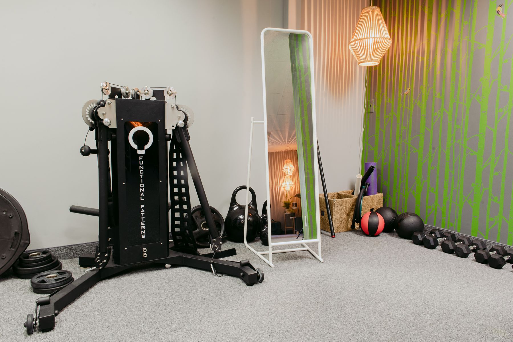 The training studio at Dr. Kimberly Berkus's Minneapolis practice, with a Functional Patterns training machine, free weights, kettlebells and a full-length mirror.