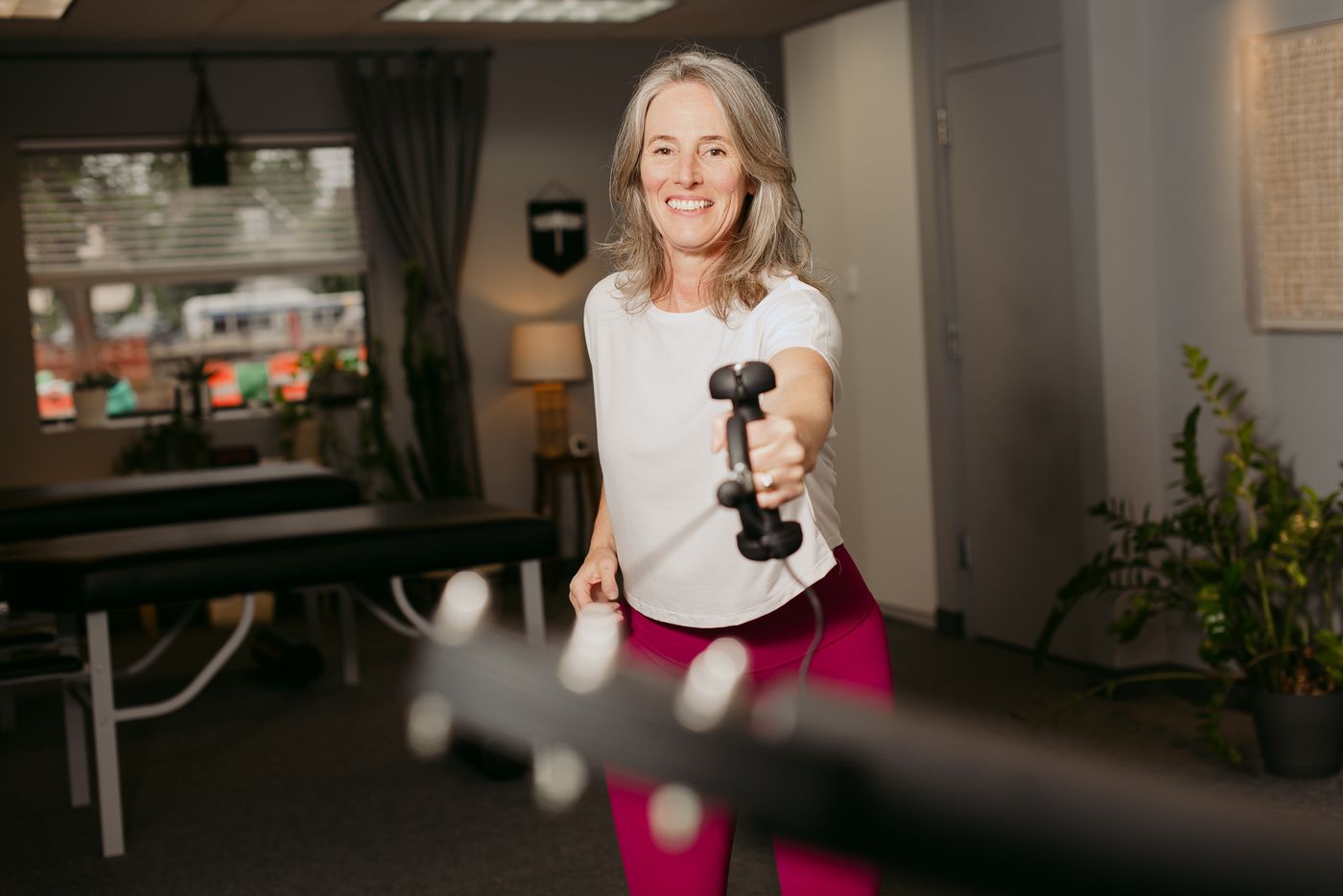 Dr. Kimberly Berkus demonstrating a cable exercise in her training studio.